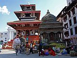 Kathmandu Durbar Square 03 04 Garuda Statue In Front of Trailokya Mohan Narayan Temple, Bimaleshwor Temple Garuda kneels with his hands in the namaste position in front of Trailokya Mohan Narayan temple in Kathmandu Durbar Square. The very small Bimaleshwor Temple is to the right. The figure of Garuda was placed here in 1690 by Riddhi Lakshmi, widow of King Bhupalendra.